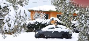 een auto bedekt met sneeuw voor een huis bij View House in Agria