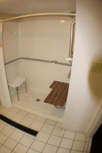 a bathroom with a bath tub with a bench in it at The Garden Inn in Elkhart