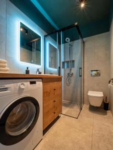 a washing machine in a bathroom with a shower at Apartament Baltic Sunrise in Sztutowo