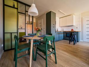 a kitchen and dining room with a table and chairs at Apartament Baltic Sunrise in Sztutowo
