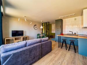 a living room with a couch and a kitchen at Apartament Baltic Sunrise in Sztutowo