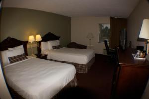 a hotel room with two beds and a desk at The Garden Inn in Elkhart