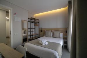a hotel room with a bed with two towels on it at Hotel La Milagrosa in Alicante