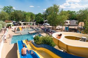 einen Pool in einem Wasserpark mit Leuten, die darin spielen in der Unterkunft Camping maeva Club Les Rivières in Canet