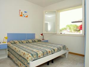 1 dormitorio con cama y ventana en Flat in Lignano Riviera, en Lignano Sabbiadoro