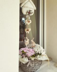 a basket of flowers with a welcome sign in a window at Antica Dimora Stucky in Treviso