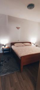 1 dormitorio con 1 cama con 2 mesas y 2 lámparas en Apartmani Sršen, en Blace