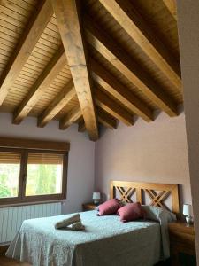 a bedroom with two beds and wooden ceilings at Los Arenales de Arcones in Colladillo