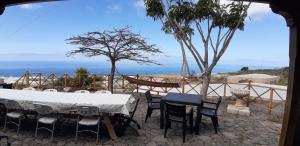una mesa y sillas con vistas al océano en Casa Rural Finca Las Dulces, en Chío