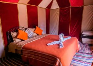 une chambre avec un lit dans une tente dans l'établissement Desert Life Camp, à Merzouga