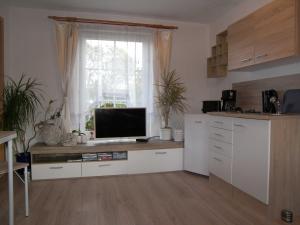 Una cocina con un escritorio con un televisor encima. en Bungalow Vincent mit Terrasse, Grill & WLAN, en Zempin