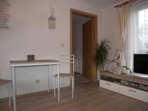 Sala de estar con mesa, mesa y TV en Bungalow Vincent mit Terrasse, Grill & WLAN, en Zempin 9 fotos más