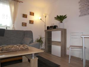 una sala de estar con un sofá y una mesa en Bungalow Vincent mit Terrasse, Grill & WLAN, en Zempin