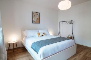una camera da letto bianca con un letto bianco e una lampada di Locarno City Apartments by Quokka 360 - flats on Piazza Grande a Locarno