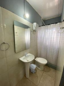 W łazience znajduje się umywalka, toaleta i lustro. w obiekcie Apartamento el uno w mieście Chuy