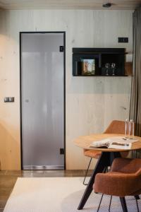 a room with a table and chairs and a door at ÖÖD Hötels Laheranna SUME -with sauna in Punakivi