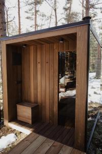 a wooden sauna with a bench in the woods at ÖÖD Hötels Laheranna SUME -with sauna in Punakivi