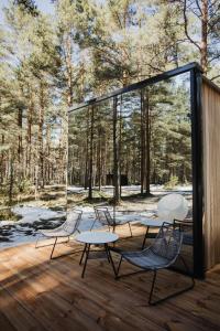 twee stoelen en een tafel op een terras met bomen bij ÖÖD Hötels Laheranna SUME -with sauna in Punakivi