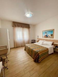a hotel room with a bed and a painting on the wall at Hotel La Bussola in Anzio