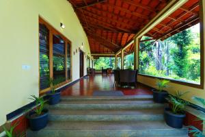 a hallway of a house with stairs and potted plants at SaffronStays Coorg Toddy Farms, Coorg in Madikeri