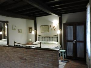 1 dormitorio con cama y pared de ladrillo en Picaza del Jerte, en Cabezuela del Valle