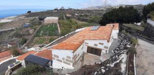 Casa Rural Finca Las Dulces في Chío: منزل على قمة تل بجوار المحيط
