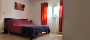 a bedroom with a bed with red curtains and a window at "à casita" villa 8 personnes avec piscine in Moriani Plage +19 photos