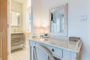a bathroom with a vanity with a mirror and a sink at Jurassic View Apartment in Lyme Regis +48 photos