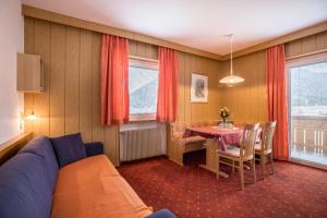 een woonkamer met een tafel en een blauwe bank bij Unterhauserhof App A in Valdaora