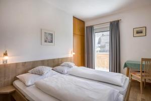 een slaapkamer met 2 bedden en een raam bij Unterhauserhof App A in Valdaora