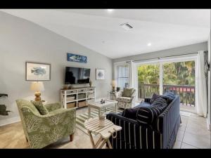 a living room with two couches and a tv at AMI/Holmes Beach - 3/2 Home - Private Heated Pool and Yard - walk to beach in Holmes Beach