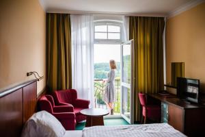 une femme qui regarde la porte d'une chambre d'hôtel dans l'établissement Royal Marianske Lazne, à Mariánské Lázně