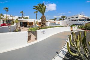 una pasarela frente a una casa con palmeras en Puerto Chico X, en Playa Blanca