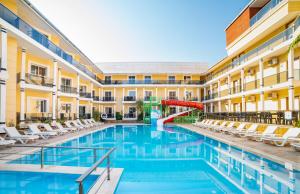 een zwembad in een hotel met stoelen en een glijbaan bij Adrasan Beach Club in Adrasan