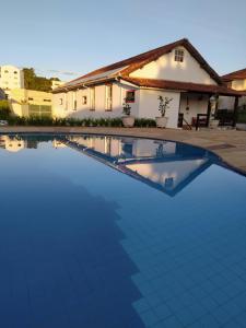 uma grande piscina azul em frente a uma casa em Pousada do Duque em Lambari