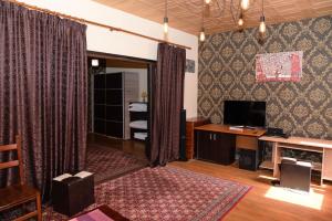 a living room with a desk and a television and curtains at Buget B&B in Focşani