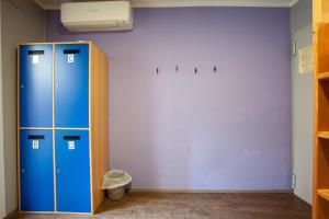a room with two blue lockers and a wall at Hostel Adriatic Piran in Piran