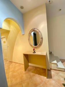 a room with a table and a mirror on the wall at Arma Faliro Rooms in Athens