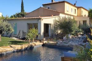 a house with a pond in front of a house at Une Oasis au Pays de Cézanne in Aix-en-Provence