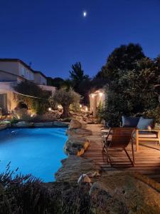 una piscina con una terraza de madera y una silla en Une Oasis au Pays de Cézanne en Aix-en-Provence