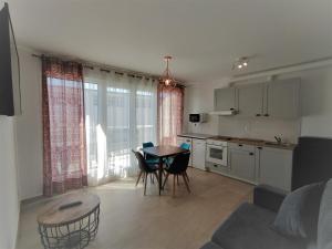 eine Küche und ein Wohnzimmer mit einem Tisch und Stühlen in der Unterkunft Apartamentos Playa De Covachos in Soto de la Marina