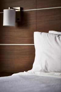 1 cama con almohada blanca y pared de madera en Holiday Inn Express - NYC Brooklyn - Sunset Park, an IHG Hotel, en Brooklyn