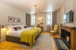 ein Schlafzimmer mit einem Bett mit einer gelben Decke in der Unterkunft The Manoir in Morzine