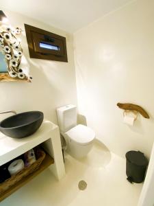 uma casa de banho com um WC branco e um lavatório. em Pistachio Guesthouse, Παραδοσιακός ξενώνας em Vathí