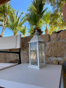 a lantern on a table with palm trees in the background at Pistachio Guesthouse, Παραδοσιακός ξενώνας in Vathí