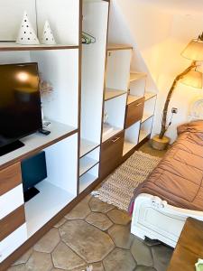 um quarto com uma cama, uma televisão e prateleiras em Pistachio Guesthouse, Παραδοσιακός ξενώνας em Vathí