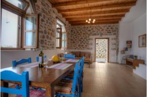 a dining room with a wooden table and blue chairs at Stone Villa II in Petres in Petres