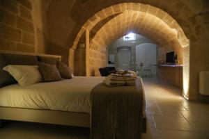 een slaapkamer met een bed in een kamer met een boog bij Suite San Placido in Matera