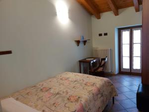 Zavattarello的住宿－LA MONTADARIA，一间卧室配有一张床、一张书桌和一个窗户。