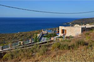 a building on a hill with the ocean in the background at Stone Villa I in Petres in Petres